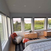 Master Bedroom Panorama-Schlafzimmer mit großen Fenstern, zwei Betten und direktem Ausblick auf Natur und Wasser.